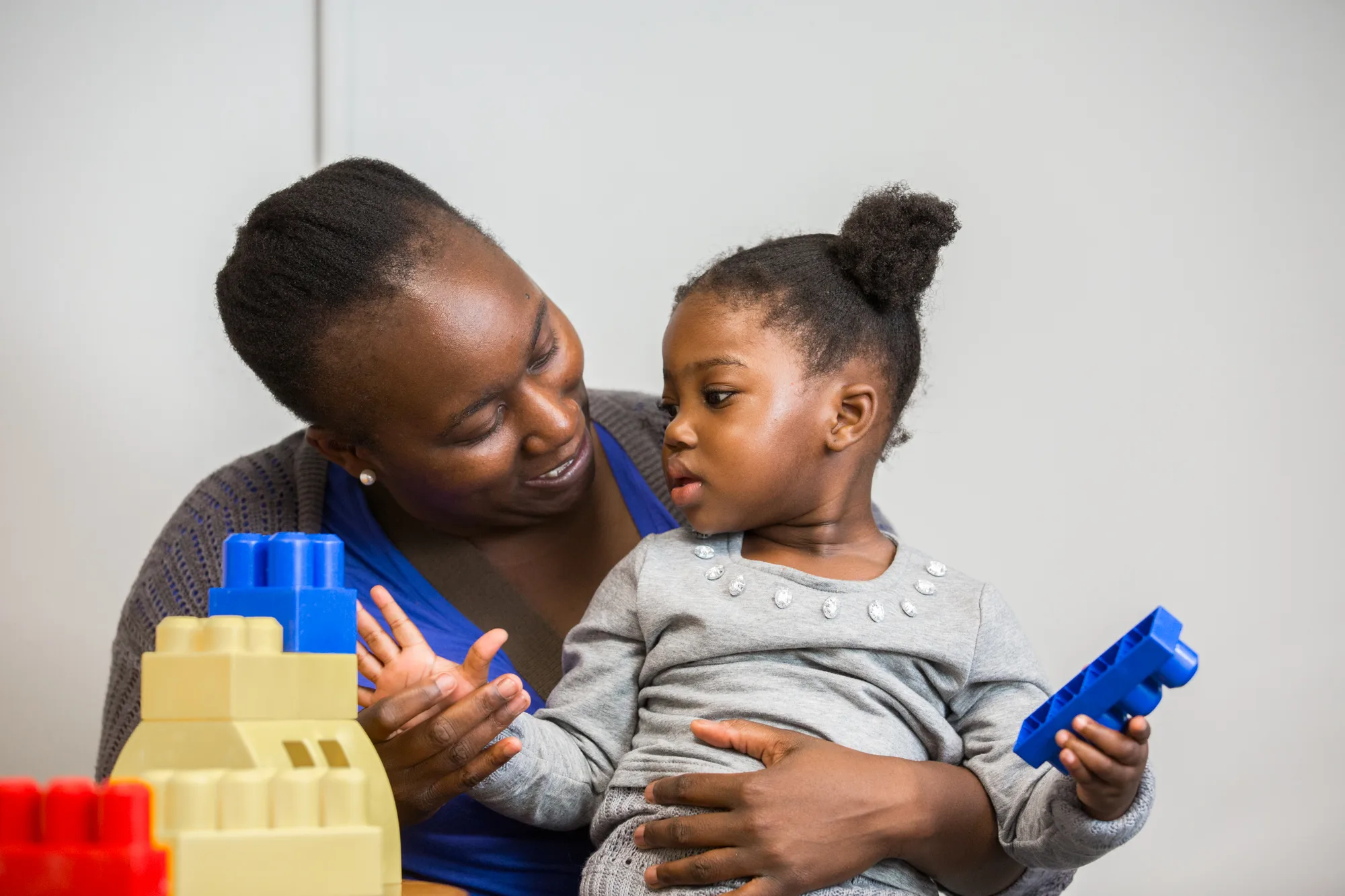 Woman and child playing with colorful blocks at the Crisis Nursery.